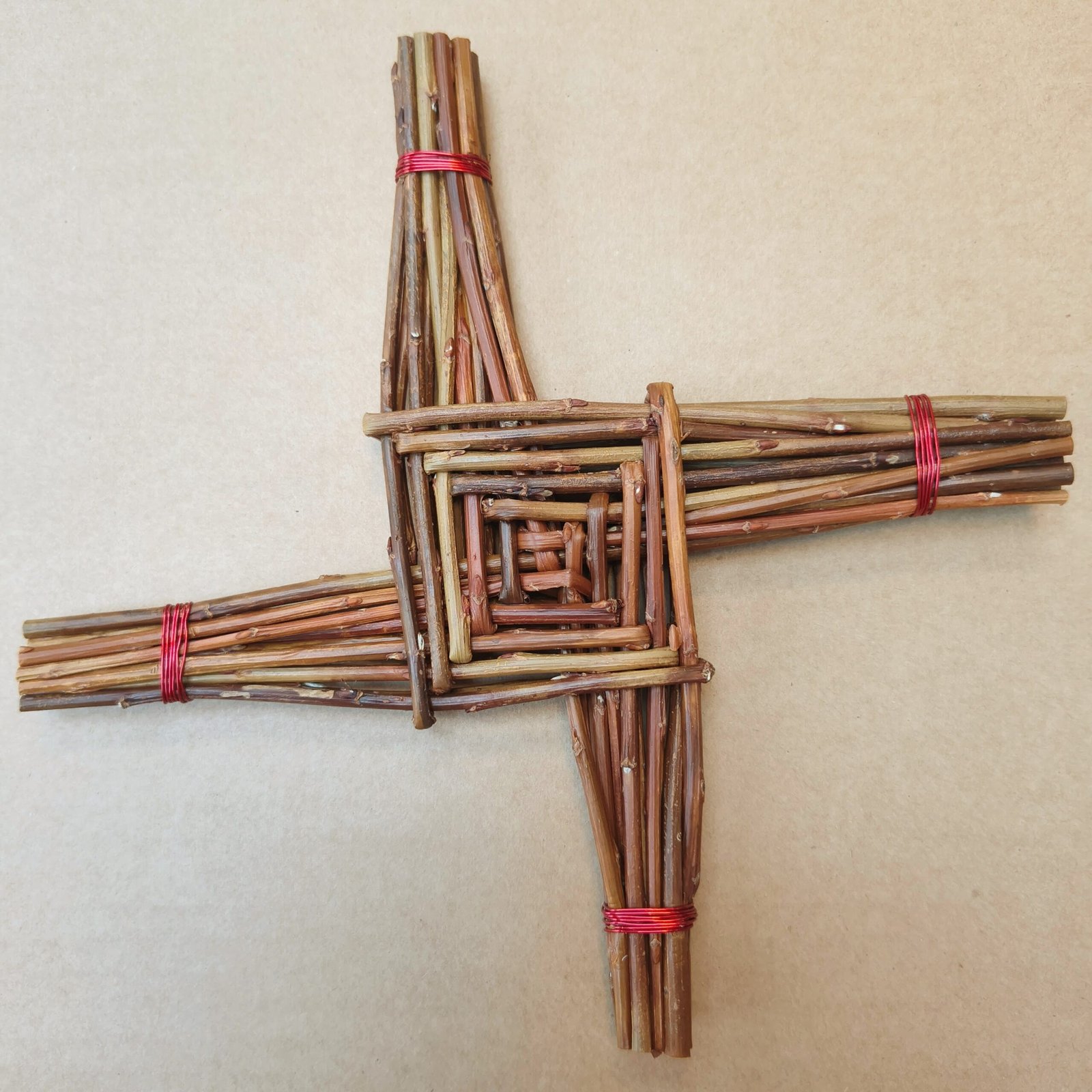 brown willow celtic cross with 4 arms. Each arm is bound with copper coloured wire.