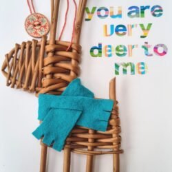 a small deer made from orange / brown willow with a teal scarf on a white card with colourful writing saying You are Deer to Me